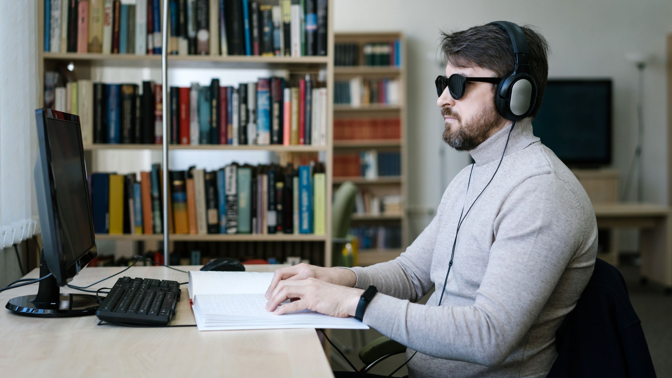 Barrierefreiheitsstärkungsgesetz 2025 Bannerbild: Mann mit Sonnenbrille und Kopfhörer am Schreibtisch vor dem Computer